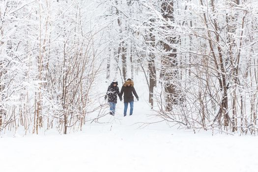 Happy loving couple having fun outdoors in snow park. Winter vacation.