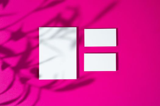 Advertising mock-up. White blank businesscards on bright pink background. copy space