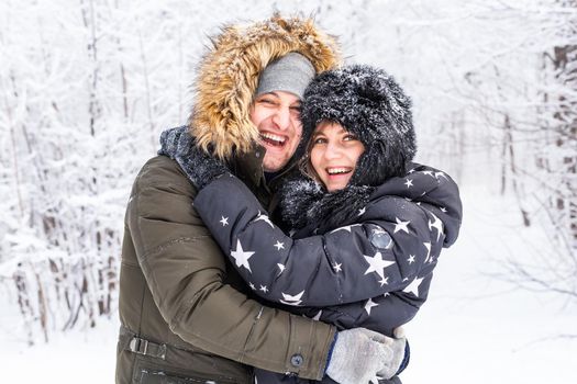 Young couple in love walks in the snowy forest. Active winter holidays