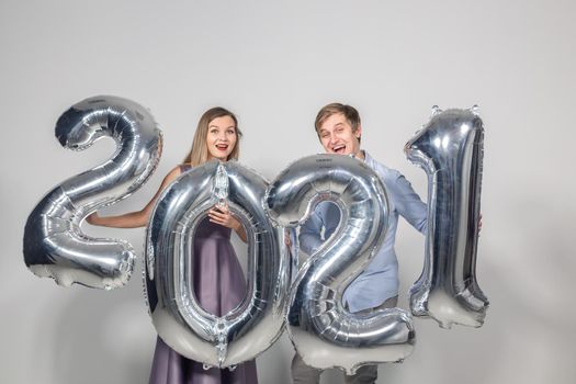 Party, people and new year holidays concept - woman and man celebrating new years eve 2021.