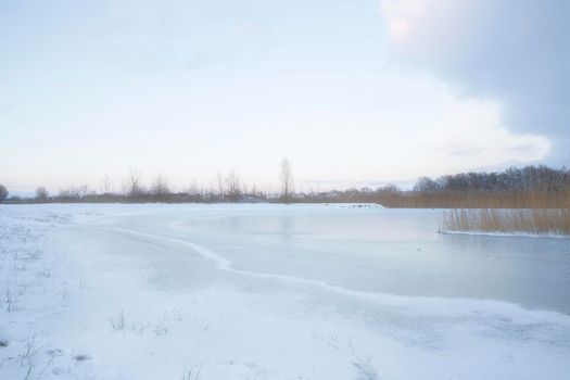 Beautiful winter landscape at sunset with fog and snow covering farmland and river in the Netherlands beautiful colors in nature winter