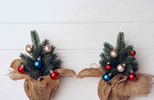 Christmas tree branches decorated with baubles on white background top view