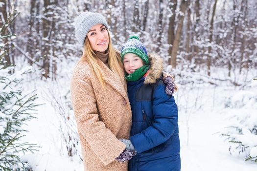 Portrait of happy mother with child son in winter outdoors. Single parent.