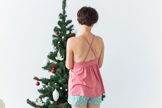 Portrait of smiling young woman decorating christmas tree