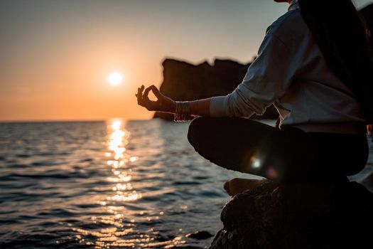 Young woman in swimsuit with long hair practicing stretching outdoors on yoga mat by the sea on a sunny day. Women's yoga fitness pilates routine. Healthy lifestyle, harmony and meditation concept.