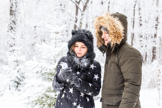 Season and relationship concept - Funny couple taking selfie in the winter time.