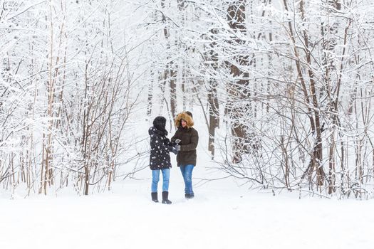 Happy loving couple having fun outdoors in snow park. Winter vacation.