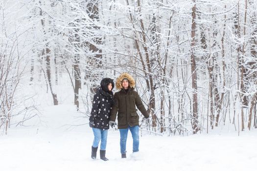 Happy loving couple having fun outdoors in snow park. Winter vacation.