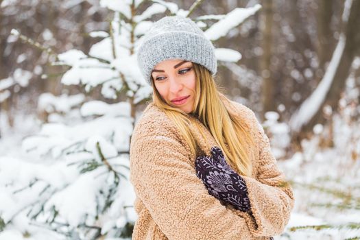 Beautiful winter portrait of young woman in the winter snowy scenery.