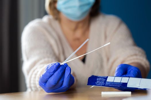 Senior woman studying and taking the self test for Covid-19, home test kit for coronavirus close-up