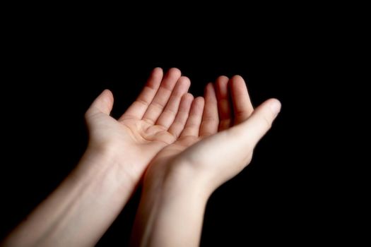 Open hands gesture for begging or praying on dark black background, faith,help,worshipper sign concept closeup
