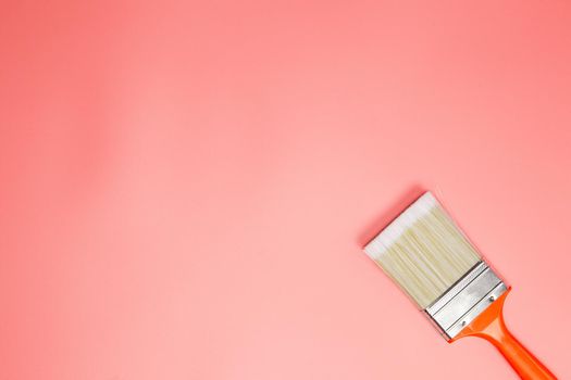 Paintbrush on pastel pink background, creative layout flatlay top view modern design with copy space colorful design