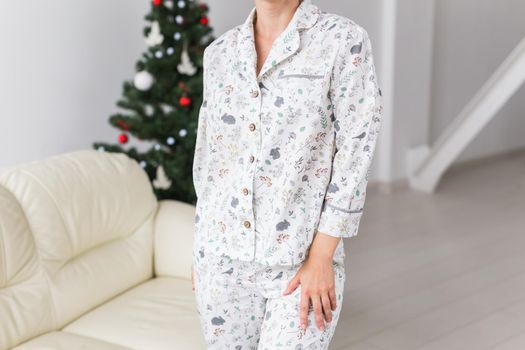 Happy young woman with lovely dog in living room with christmas tree. Holidays.