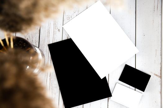 white and black empty blank business card and flyer for copy space on white wooden background, replace your design. Modern style concept with pampas grass