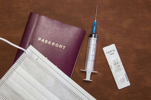 COVID-19, travel and lockdown concept, Passport with negative rapid test and syringe for requirement traveling coronavirus, virus,health,vaccination concept on natural brown leather background texture copy space
