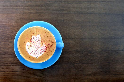 Big Coffee cup with milk on the wooden table. cappuccino or latte drink, cup of coffee on brown table flat lay view. Cup of cafe au lait. Milk paintings or latte art. Hot Coffee in a blue mug