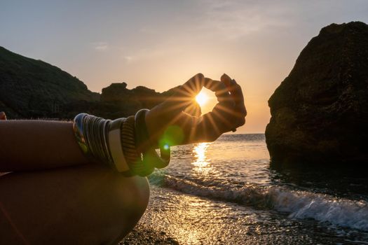 Young woman in swimsuit with long hair practicing stretching outdoors on yoga mat by the sea on a sunny day. Women's yoga fitness pilates routine. Healthy lifestyle, harmony and meditation concept.