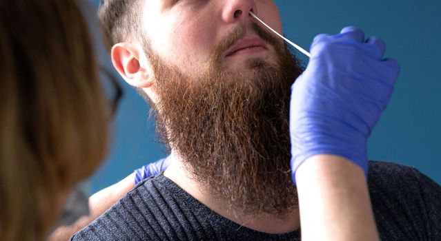 Woman doing nasal swab with self test kit at home from a young man for testing possible coronavirus infection. Covid-19,Coronavirus,Healht,selftest concept close up