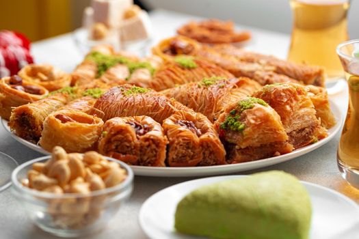Various Turkish sweets and cup of tea on white textured background, close up