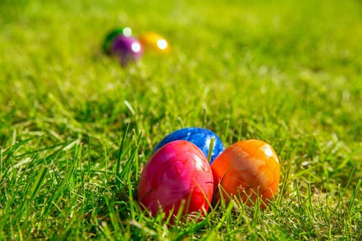 Colorful painted Easter eggs in the bright fresh green grass, concept for Easter Holliday, spring background with copy space space for text