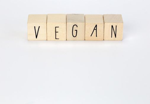 Vegan and hashtag written with wooden cubes and nature decoration isolated on white background with copy space, vegan,vegetarian,health concept background modern design natural style close up