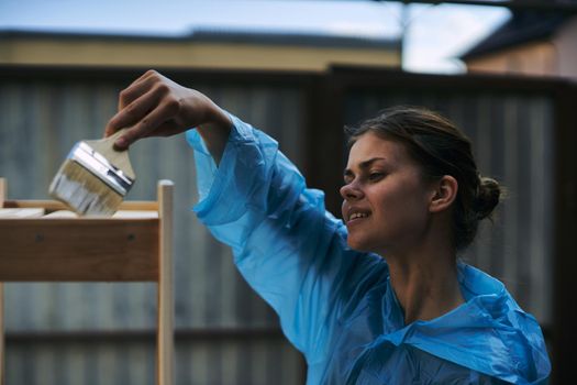 woman paints wood painter repair protective suit. High quality photo