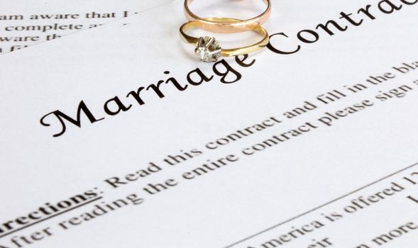 Marriage contract with two golden wedding rings and gold pen, prenuptial agreement, macro close up, sign with signanture,document,agreement concept romance