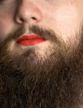 Bearded Man with Red Lipstick on His Lips , handsome pride transgender portrait lgbtq, transsexual concept closeup