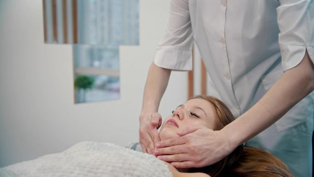 Massage - a masseuse is massaging her clients neck - indoor