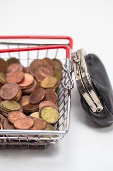 Iron shopping basket filled with euro coins isolated on white background, business and financial concept