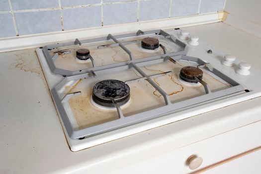 Dirty gas stove cooking oil stains on gas stove in kitchen.An Unclean and Dirty Kitchen used For Cooking Food and Preparing Meals, needs cleaning, close up unhealthy,dirty