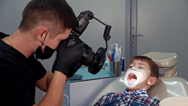 A little boy having a treatment in the dentistry - the boy with opened mouth. Mid shot