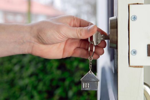 landlord, Estate agent or new home owner opening the door of a cozy new home with silver key, invesment real estate, business, financial concept copy space close up