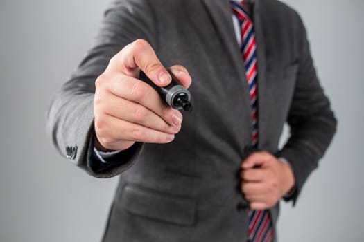 Businessman standing posture hand hold a pen isolated on over grey background