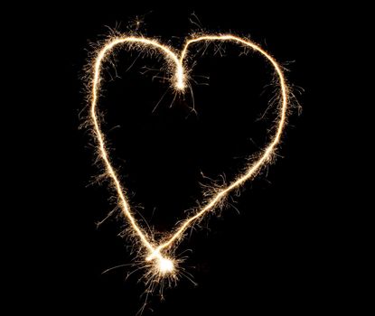 Sparkler heart made of fireworks. Good design element for romantic wedding, Valentine's Day or love concept beautiful light effect