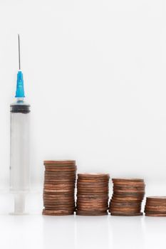 Syringe fot health concept with coin stacks on white background, business,financial and health,vaccination concept. copy space