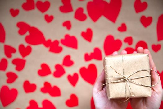 Hands holding beautiful gift box, female giving gift, Valentine's Day, holidays and greeting season concept, top view background romantic design