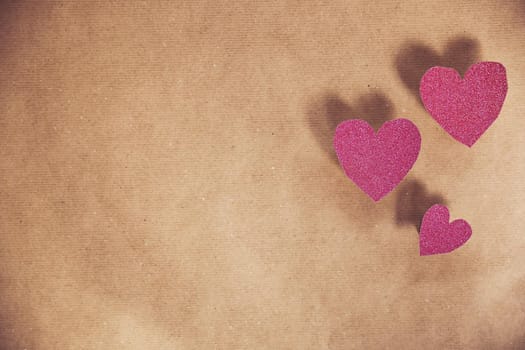 Romantic pink heart on brown plain paper background texture for romantic concept, Valentine's Day, Mother's Day other holliday. Copy space vintage design