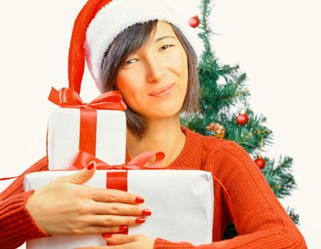 Young woman in santa hat is smiling and hugging gift box