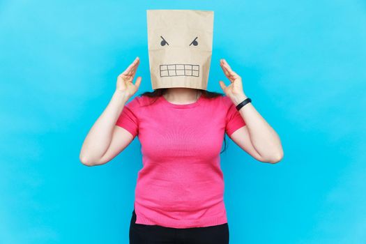 Woman standing with a cardboard on her head with angry face. Emotions.