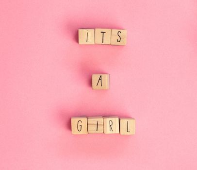 Its a Girl text written with wooden cubes on pastel white background top view, Baby announcement. Flat lay,text space. Greeting card, shower, baby concept bright colorful design cute