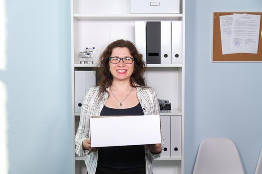 Concept of dismissal from work. Happy woman with carton box with her stationery stuff, girl was fired from her job