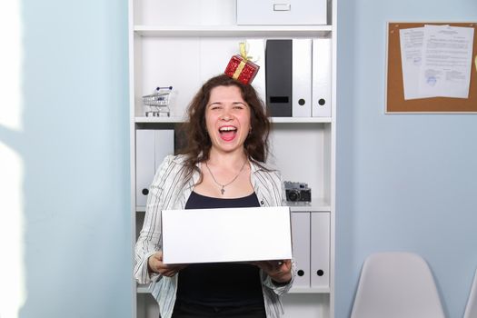 Concept of dismissal from work. Happy woman with carton box with her stationery stuff, girl was fired from her job