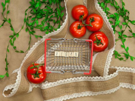 Vegan written on wooden cubes surrounded with vegetables in shoppin basket top view with craft paper background, Vegan, Healthy food, Vegetarian concept, copy space lifestyle