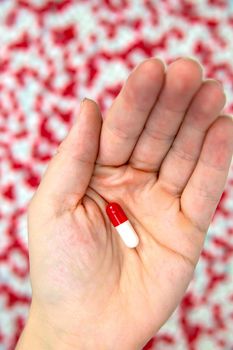 hands holding red and white capsules for medication, vitamin or drugs background on white background. Top view. Flat lay. Copy space. Close up. Medicine,business and health concept colorful