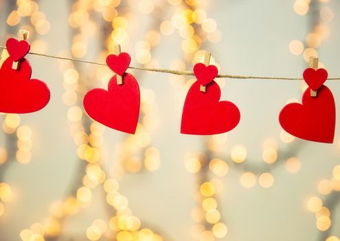 Happy Valentine day background with red hearts hang with clothespin on rope with bokeh background, romantic design, greeting card or copy space space for text
