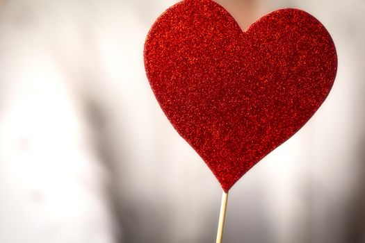 Female hands holding sparkling red heart near body, taking care, Health, Valentine's Day concept romantic design love background