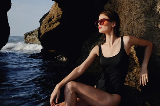 woman in black swimsuit sunglasses summer rocks exotic. High quality photo