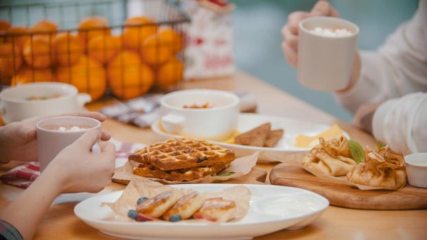 A couple in restaurant having a breakfast of waffles and pancakes. Mid shot