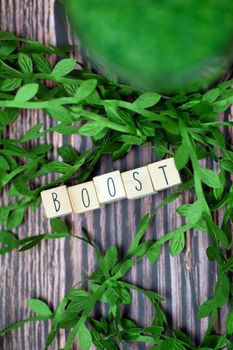 Boost text wooden cubes, your immune system text with wooden cubes and fresh organic leafs on background with wood texture, Boost for Healht concept background